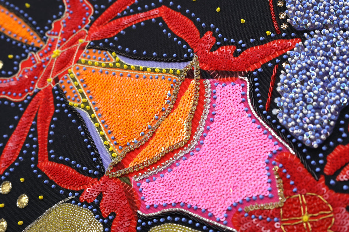 Sacred Offering (Black) detail: red beaded blossom on black cotton canvas